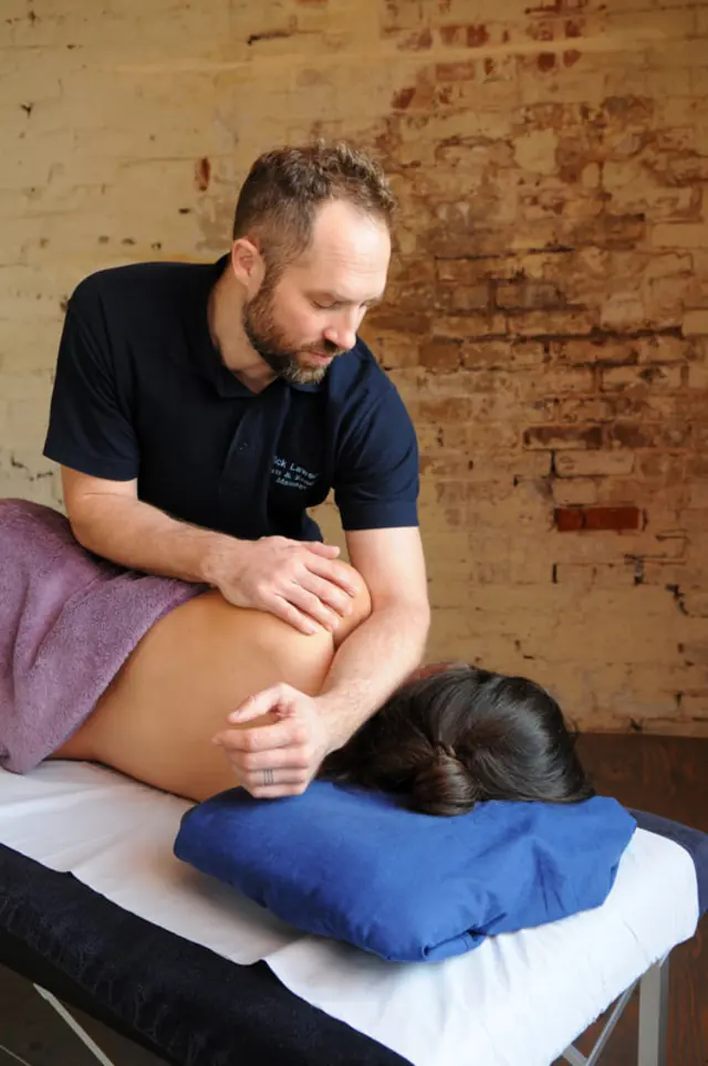 Nick providing focused massage treatment in a professional treatment room.